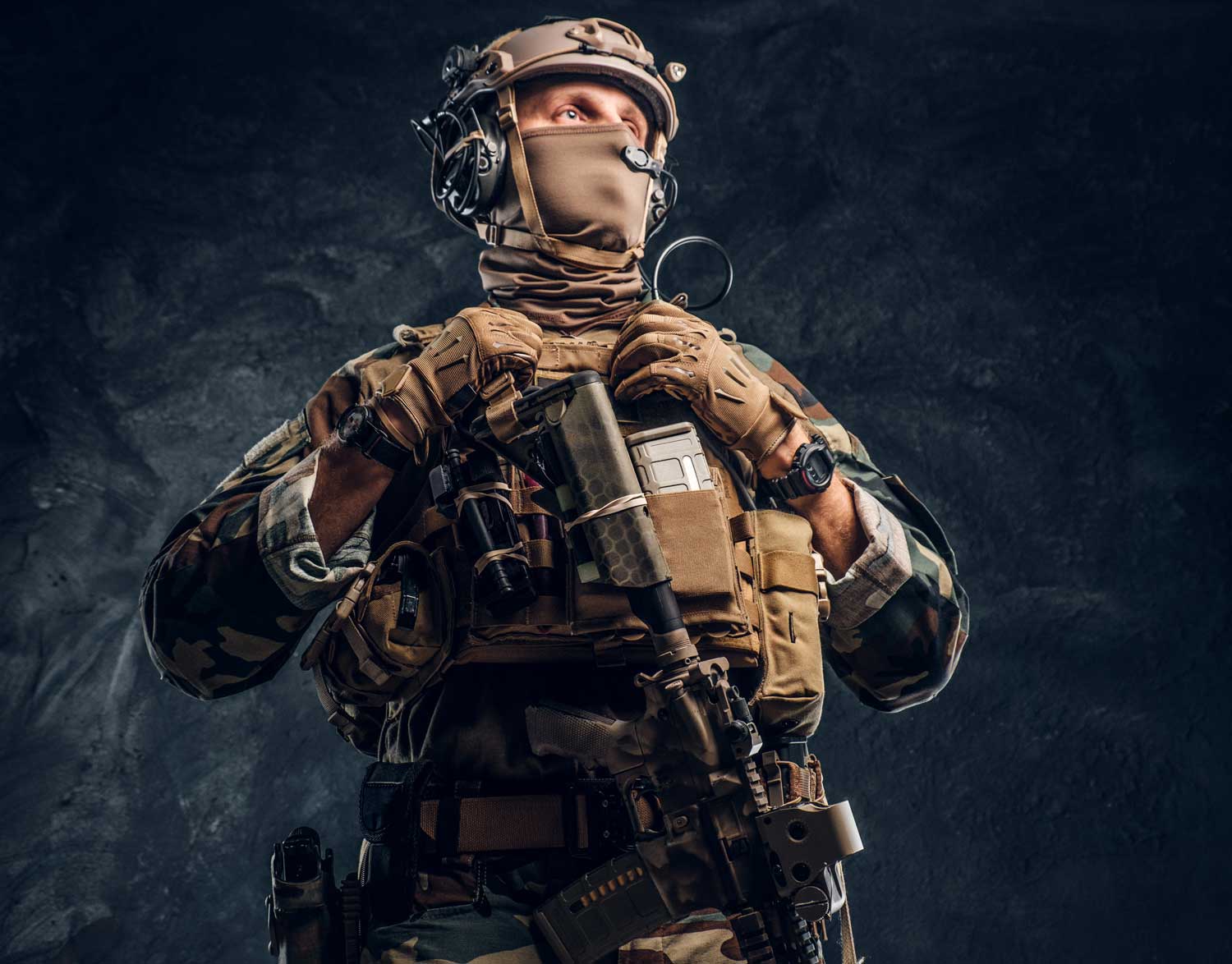 elite unit special forces soldier camouflage uniform studio photo against dark textured wall