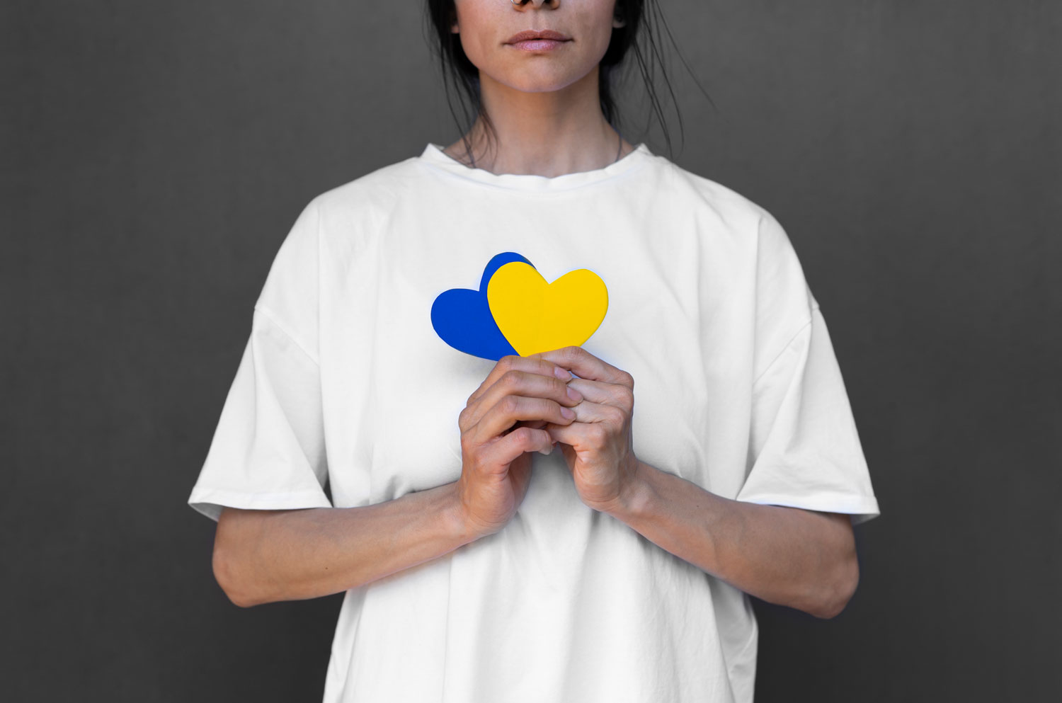 front view woman holding yellow blue hearts