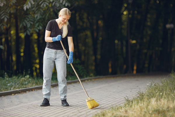 woman collects leaves cleans park thumb